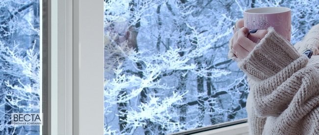 Девушка около пластикового окна с зимним пейзажем
